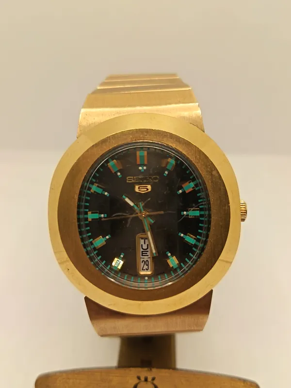 Reloj seiko automatico con esfera negra y caja dorada funcionando